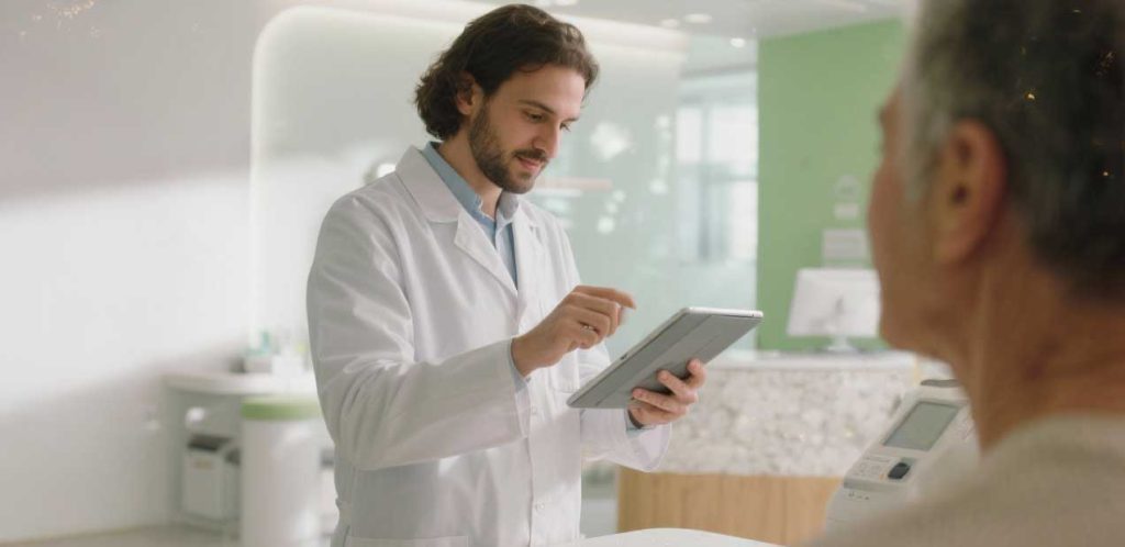 Εξειδικευμένος ακοοπροθετιστής της Akouson εξυπηρετεί πελάτη σε σύγχρονο κέντρο ακοής